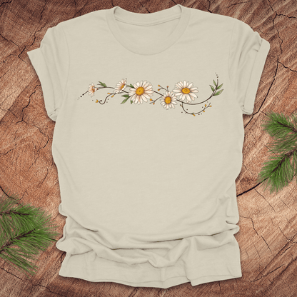 Beige t-shirt with daisy design on a wooden surface