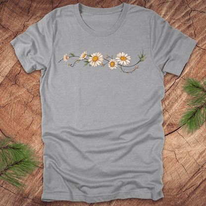 Gray t-shirt with daisy design on a wooden surface