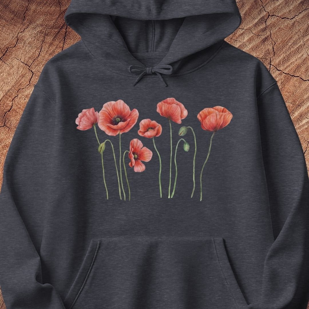 A dark heather gray hoodie featuring a graphic print of five red poppy flowers with green stems on the chest, displayed flat against a textured brown wood background.