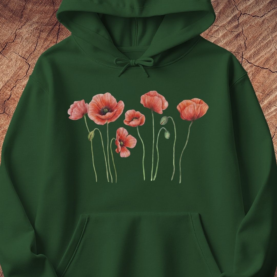 A dark green pullover hoodie featuring a graphic print of pink poppy flowers with green stems across the chest, displayed flat against a textured brown wood background.