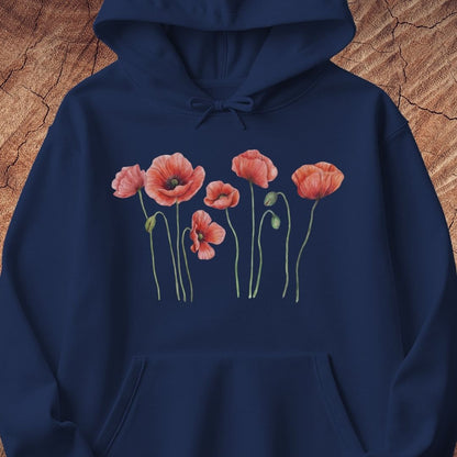 A navy blue pullover hoodie featuring a watercolor-style graphic of pink poppy flowers with green stems on the chest, displayed against a textured brown wood background.