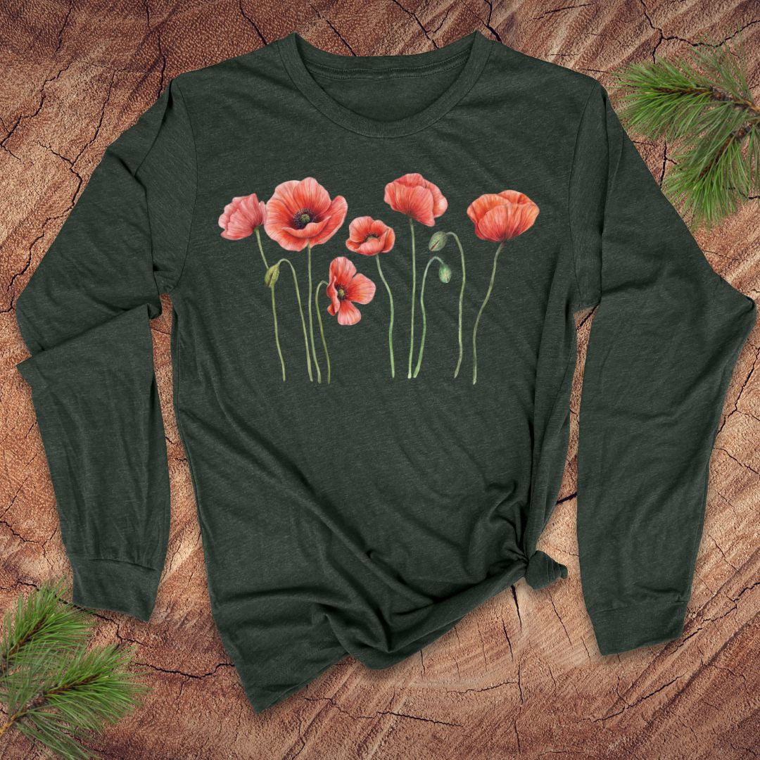 Green long-sleeve tshirt with pink poppies design on a wooden surface