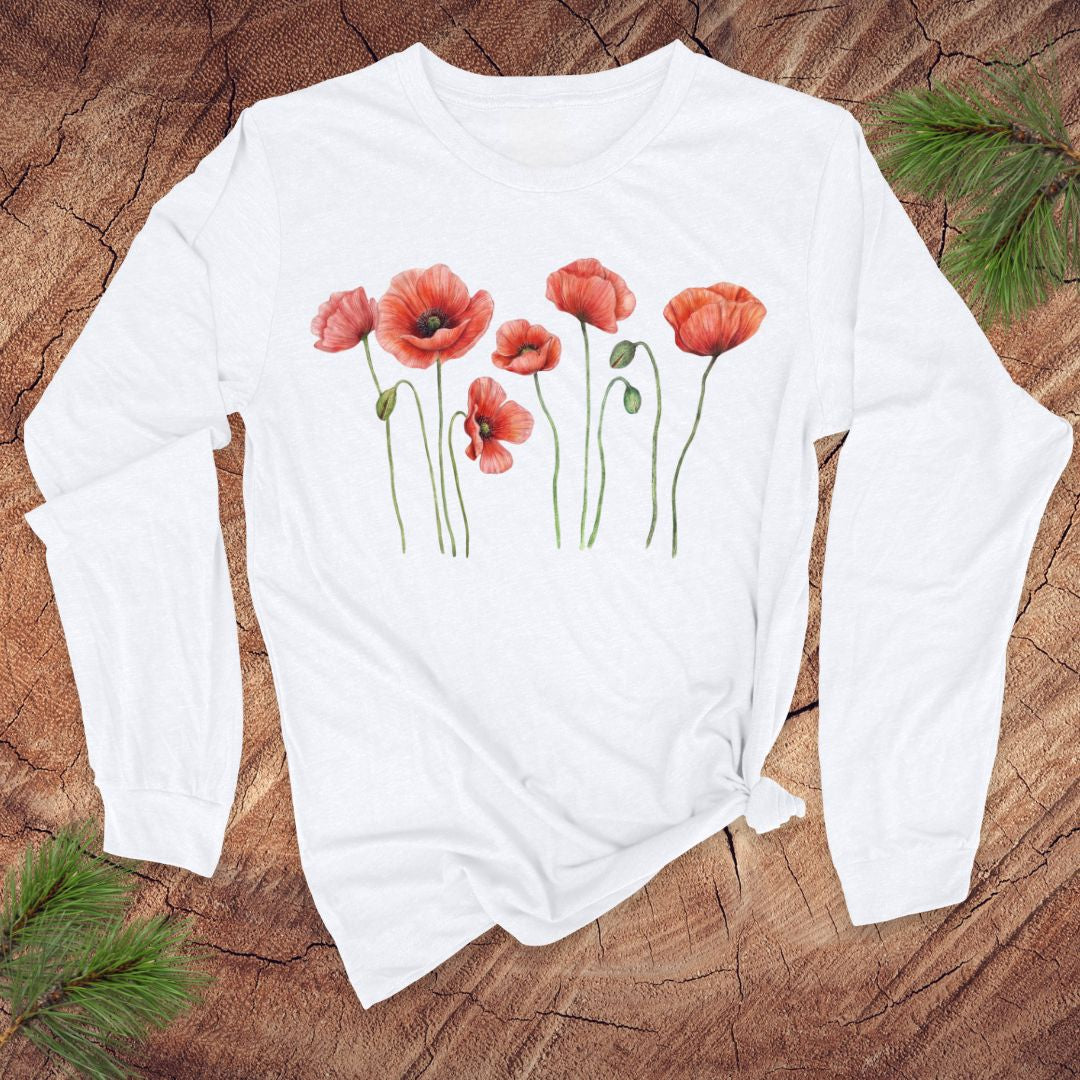 White long-sleeve tshirt with pink poppies design on a wooden surface