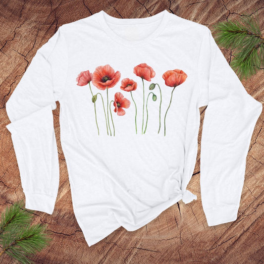 White long-sleeve tshirt with pink poppies design on a wooden surface