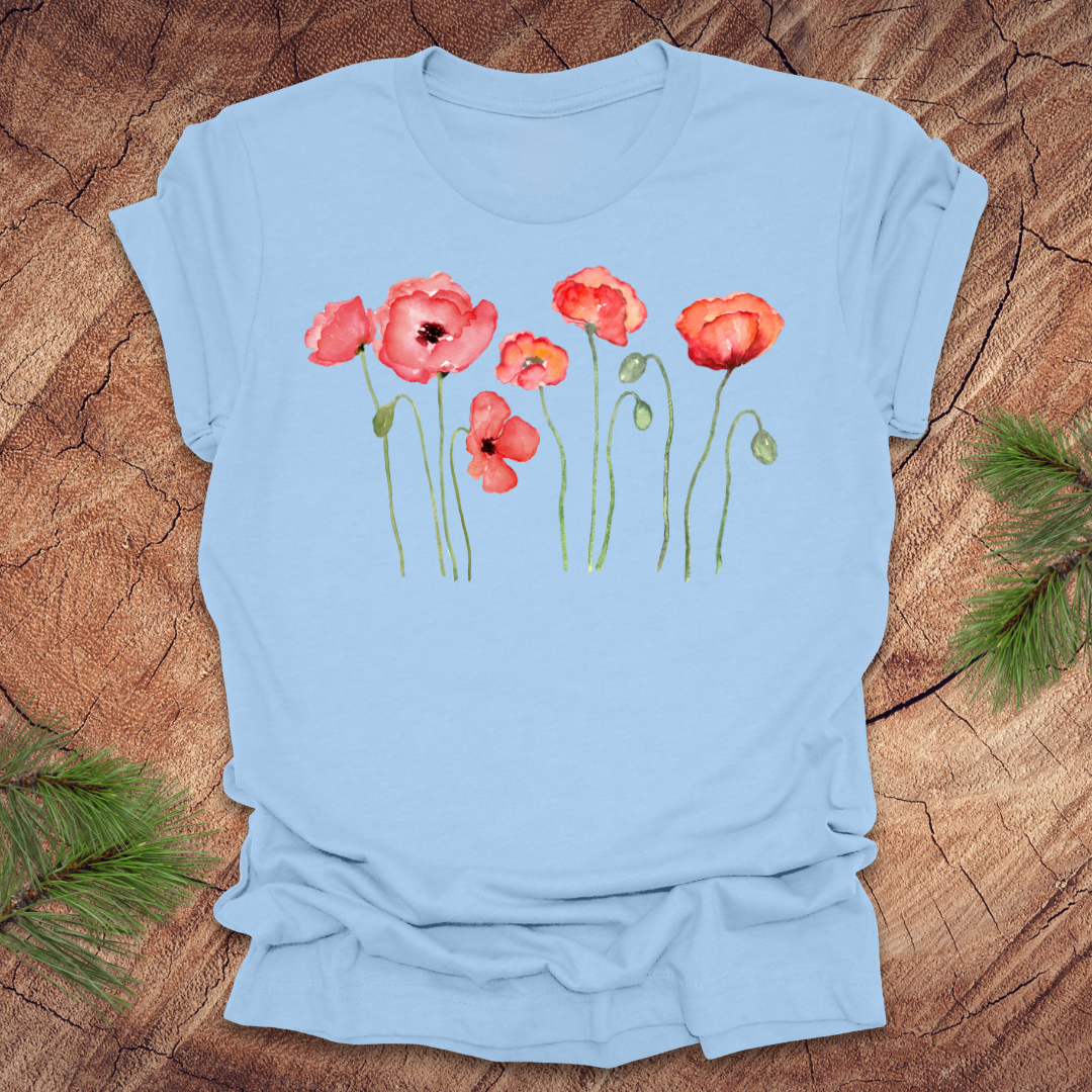 Baby blue t-shirt with red poppy design on a wooden surface