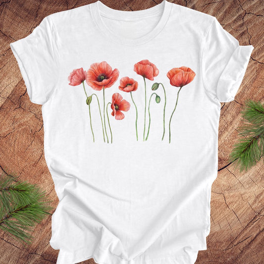 White t-shirt with individual poppy flowers on a wood background.