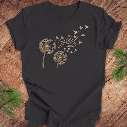 Dark gray t-shirt with dandelion and bird design on a wooden surface