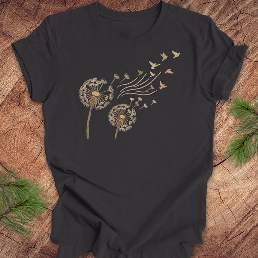 Dark gray t-shirt with dandelion and bird design on a wooden surface