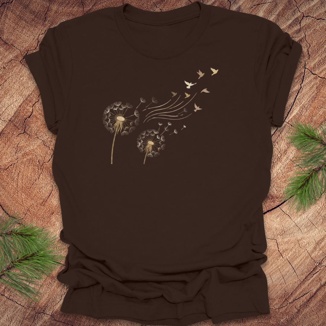 Brown t-shirt with dandelion and bird graphic on a wooden surface