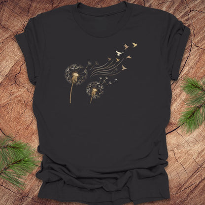 Dark gray t-shirt with dandelion and bird graphic on a wooden surface