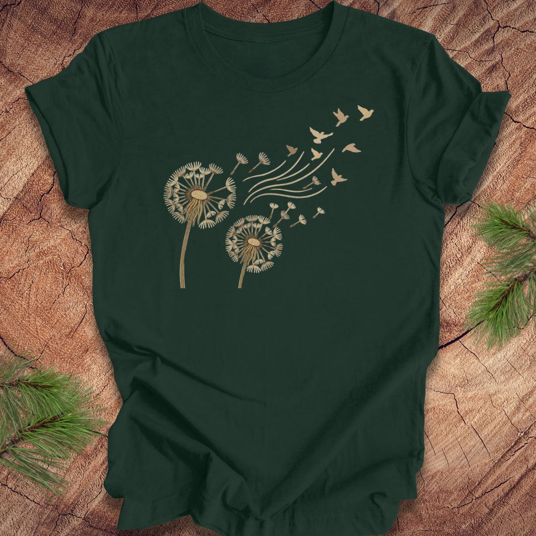 Green t-shirt with dandelion and bird design on a wooden surface