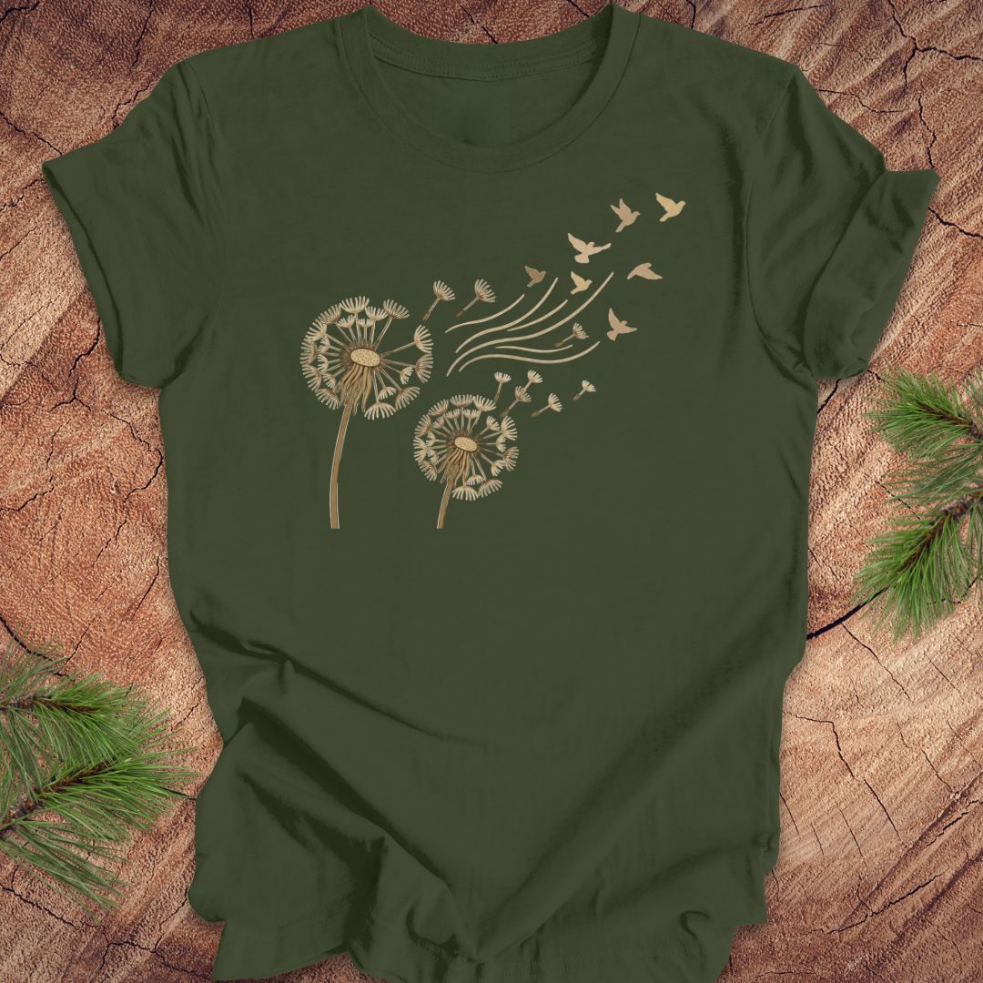 Green t-shirt with dandelion and bird design on a wooden surface