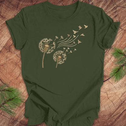 Green t-shirt with dandelion and bird design on a wooden surface