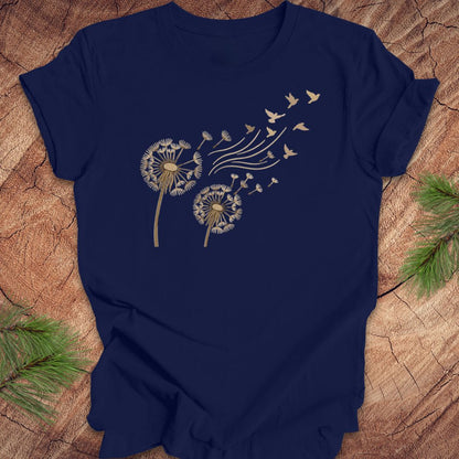 Navy blue t-shirt with dandelion and bird design on a wooden surface