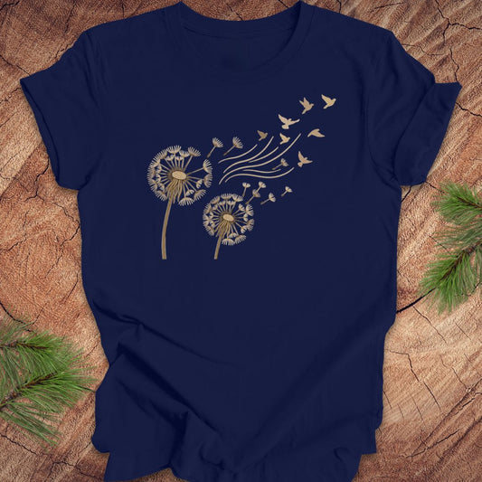 Navy blue t-shirt with dandelion and bird design on a wooden surface