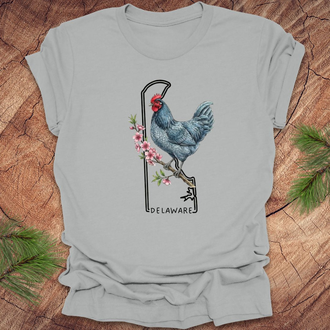 Gray t-shirt with a rooster design and 'Delaware' text on a wooden surface.