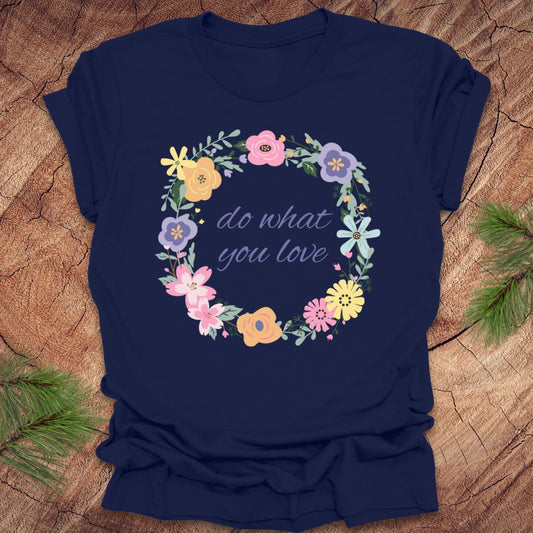 A Navy blue t-shirt with a floral wreath design and text, 'Do what you love' on a wood background.