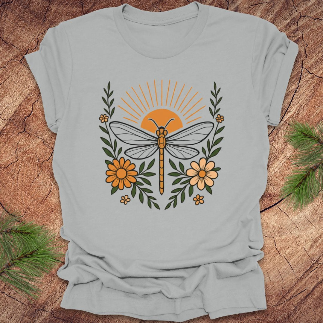 Gray t-shirt with a dragonfly and floral design on a wooden surface