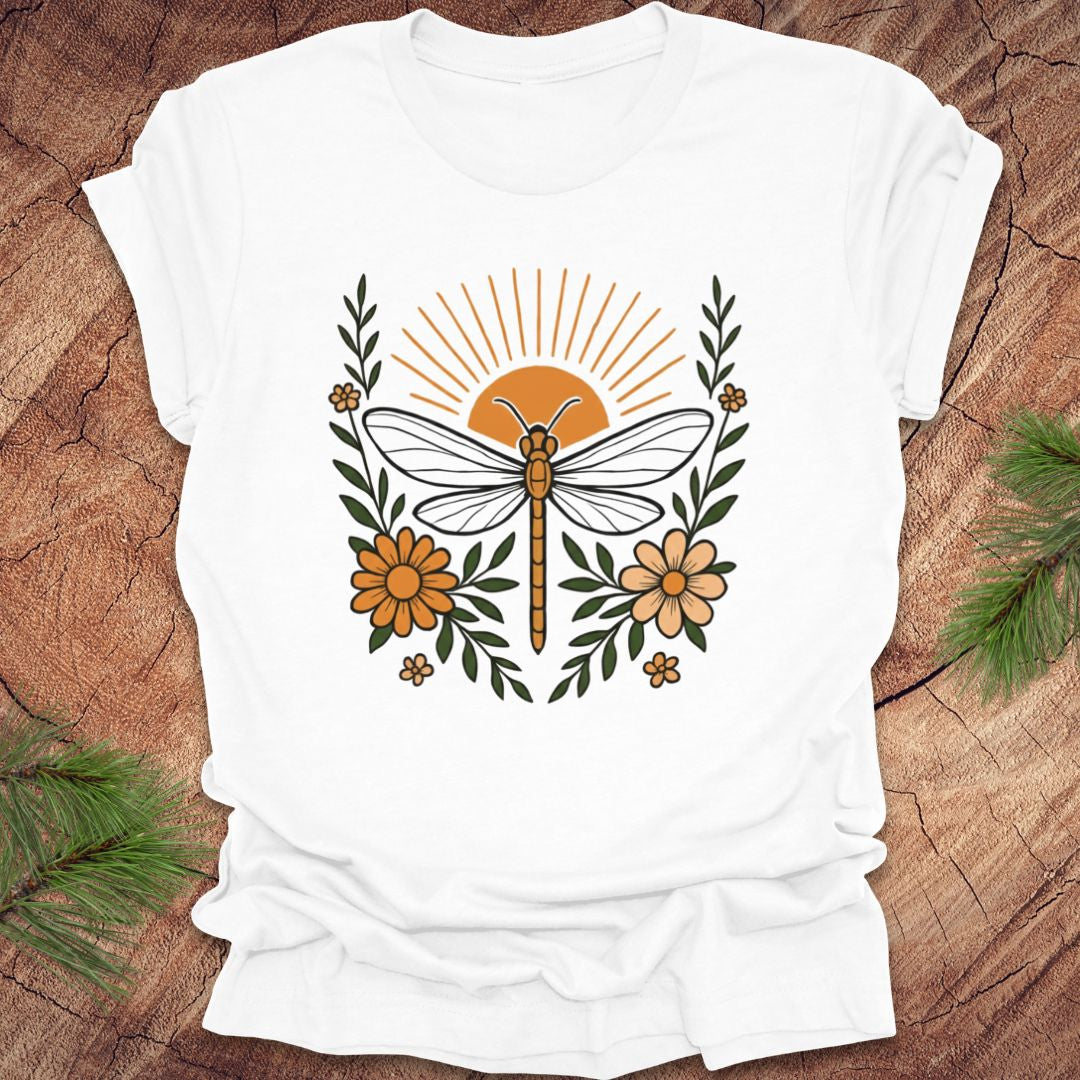 White t-shirt with a dragonfly and floral design on a wooden surface