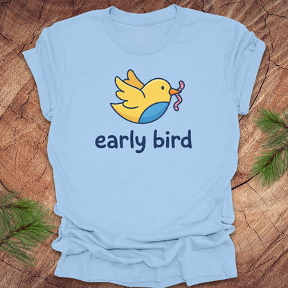 Light blue t-shirt with a yellow bird graphic and 'early bird' text on a wooden surface.