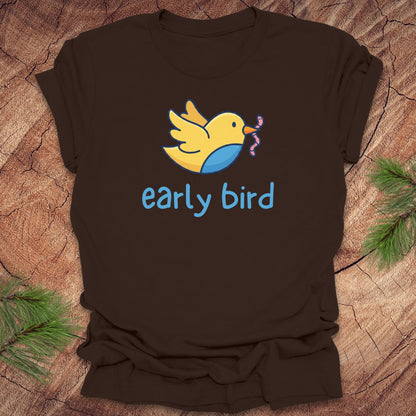 Brown t-shirt with a yellow bird graphic and 'early bird' text on a wooden surface.
