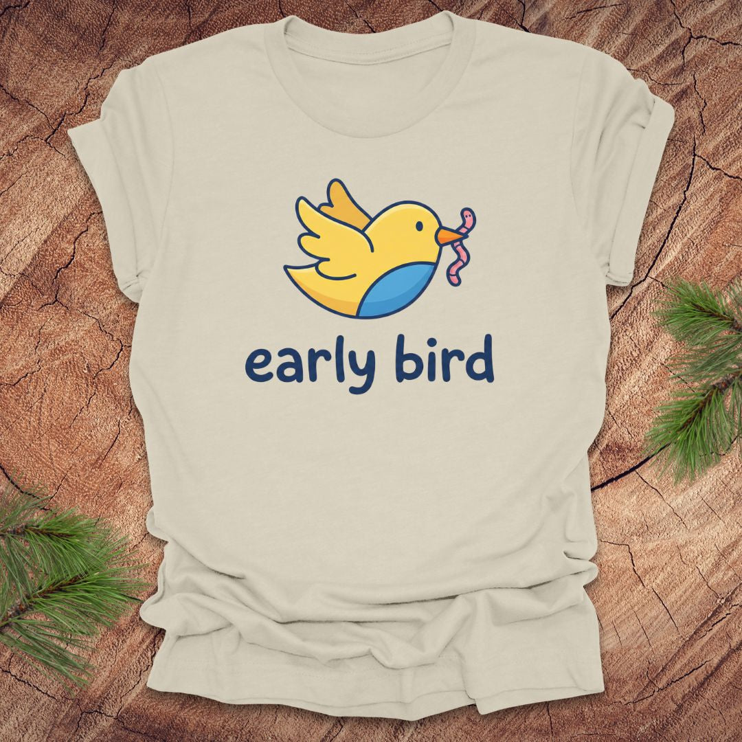 Beige t-shirt with a cartoon bird and 'early bird' text on a wooden surface