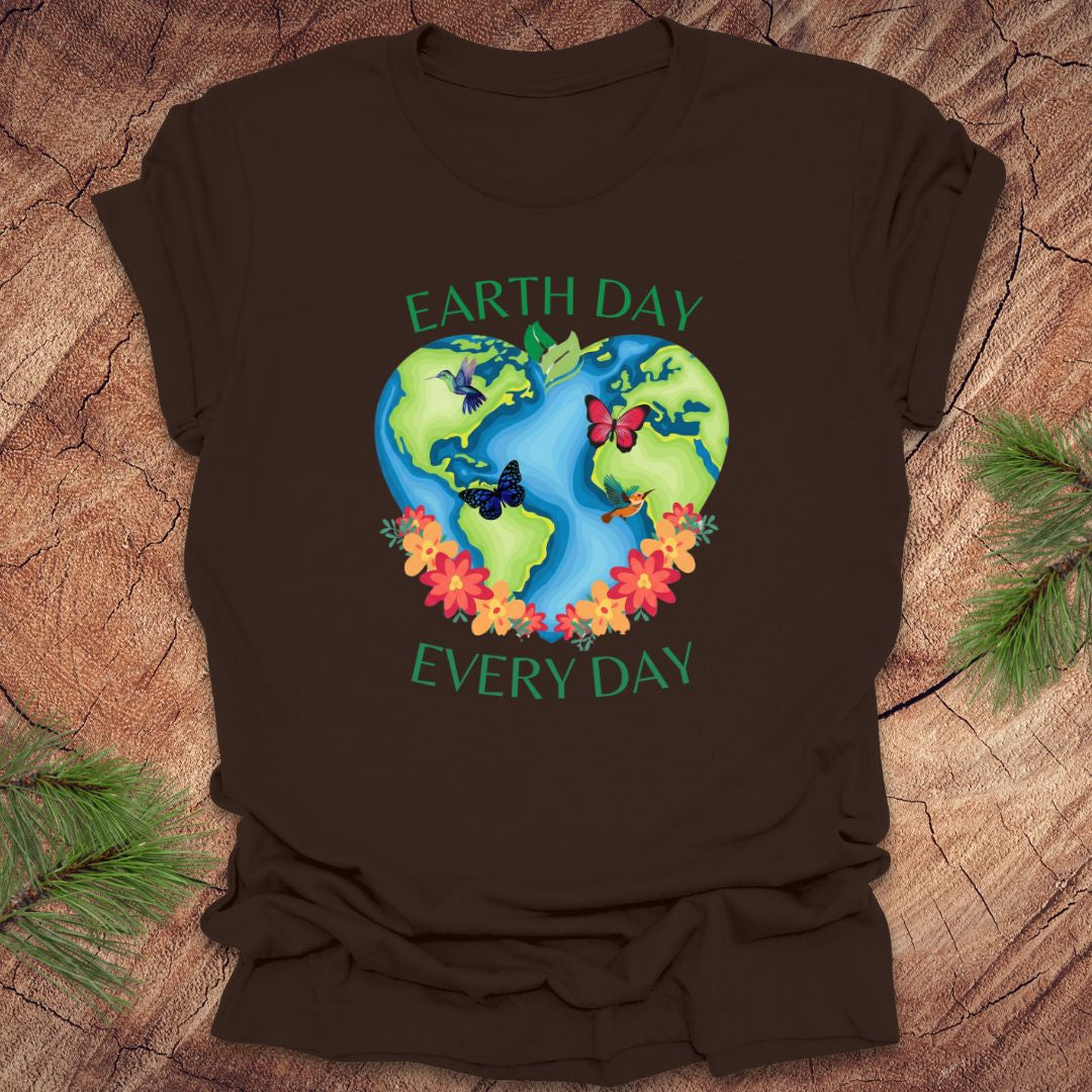 Brown t-shirt with Earth Day design featuring the Earth, flowers, and butterflies on a wooden surface.