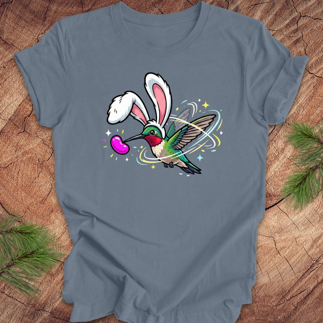 Steel blue t-shirt with a colorful graphic of a hummingbird with bunny ears on a wooden surface.