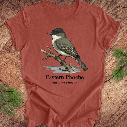 Clay colored t-shirt with an illustration of an Eastern Phoebe bird on a wooden surface.