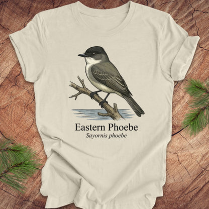 Beige t-shirt with an illustration of an Eastern Phoebe bird on a wooden surface.