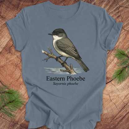 Blue t-shirt with an illustration of an Eastern Phoebe bird on a wooden surface.