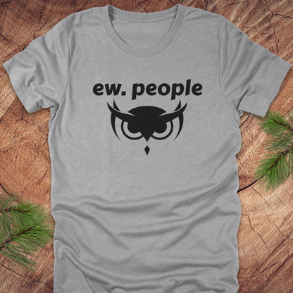 Gray t-shirt with 'ew. people' text and owl design on a wooden surface.
