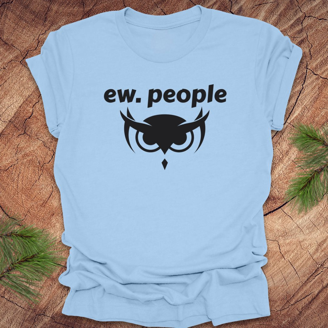Light blue t-shirt with black owl graphic and 'ew. people' text on a wooden surface.