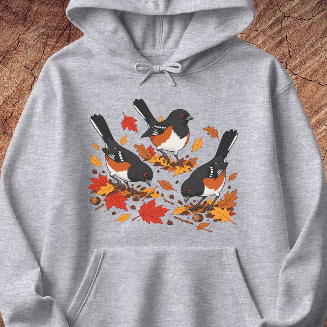 A gray hooded sweatshirt with 3 towhee birds among fall leaves, on a wood background.