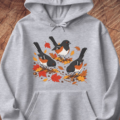 A gray hooded sweatshirt with 3 towhee birds among fall leaves, on a wood background.
