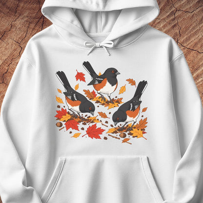A white hooded sweatshirt with 3 towhee birds among fall leaves, on a wood background.