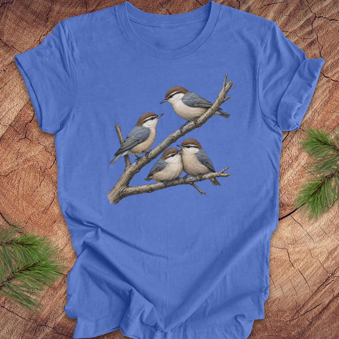 Blue t-shirt with nuthatch bird design on a wooden surface