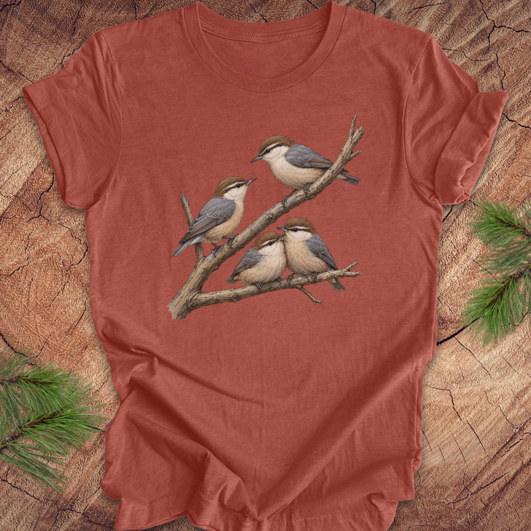Clay colored t-shirt with nuthatch bird design on a wooden surface