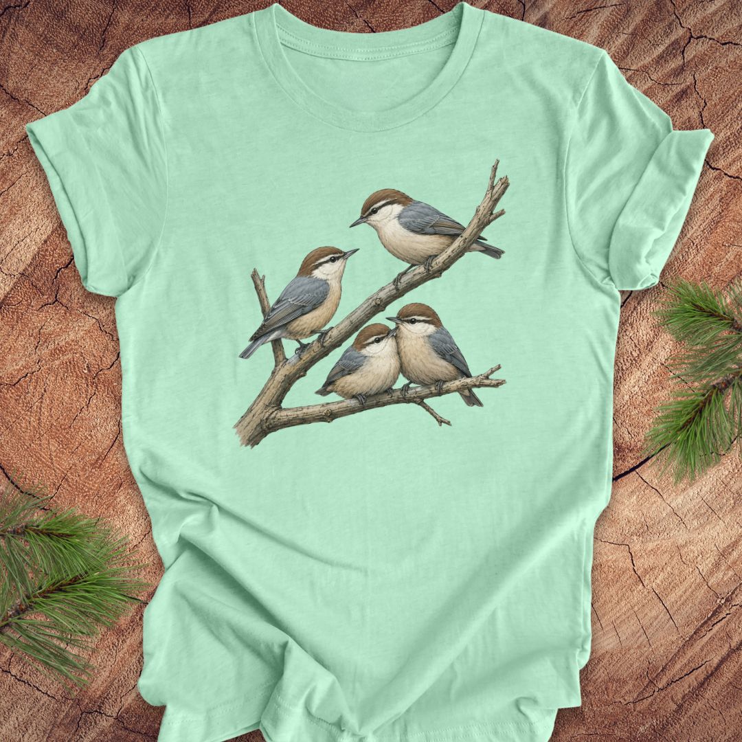 Mint green t-shirt with nuthatch bird design on a wooden surface