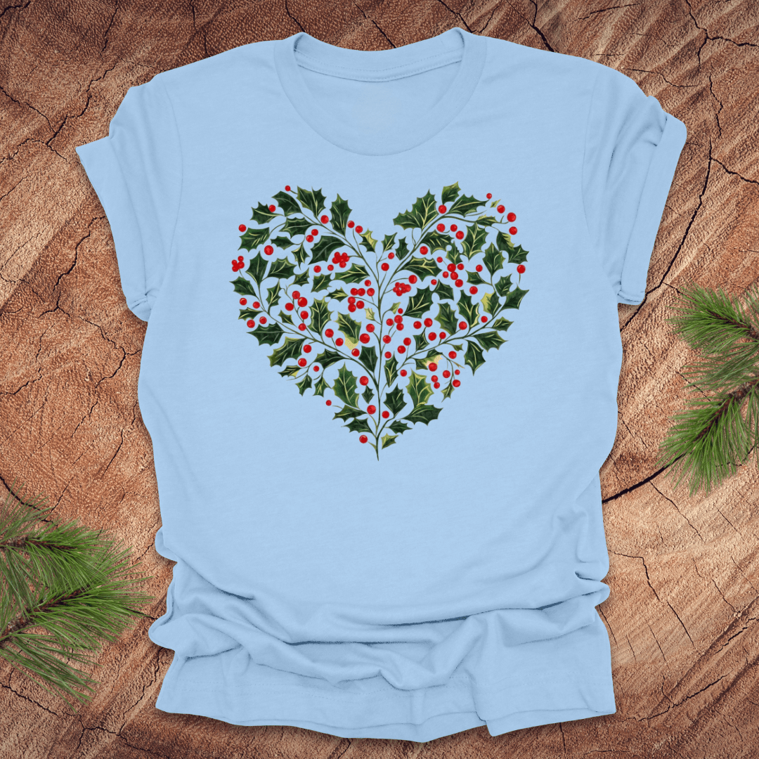 Light blue t-shirt with a heart-shaped holly design on a wooden surface.