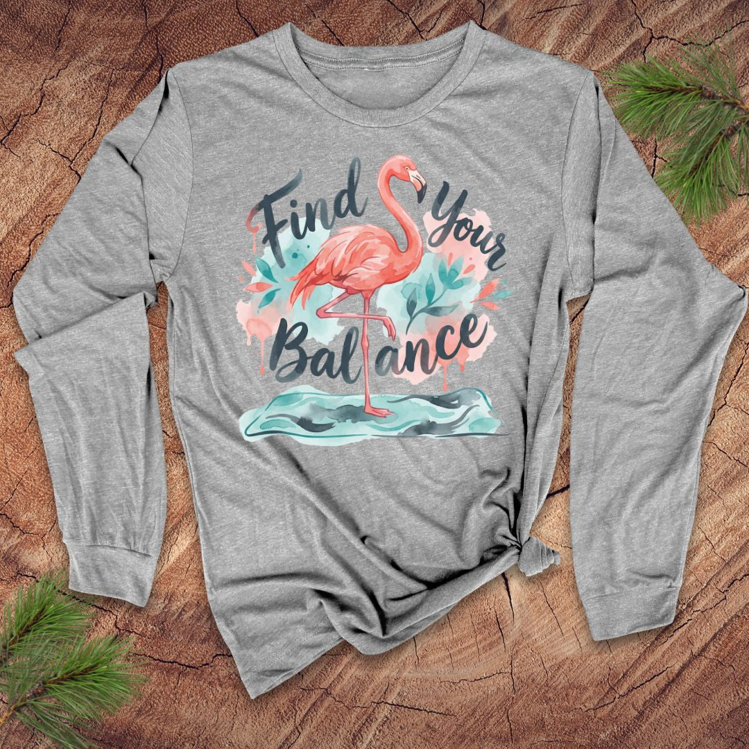 Gray long-sleeve shirt with a flamingo graphic and 'Find Your Balance' text on a wooden surface.