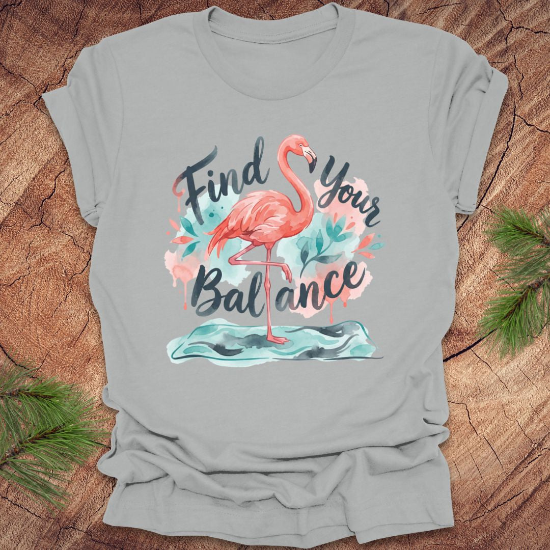 Gray t-shirt with a flamingo graphic and text 'Find Your Balance' on a wooden surface.