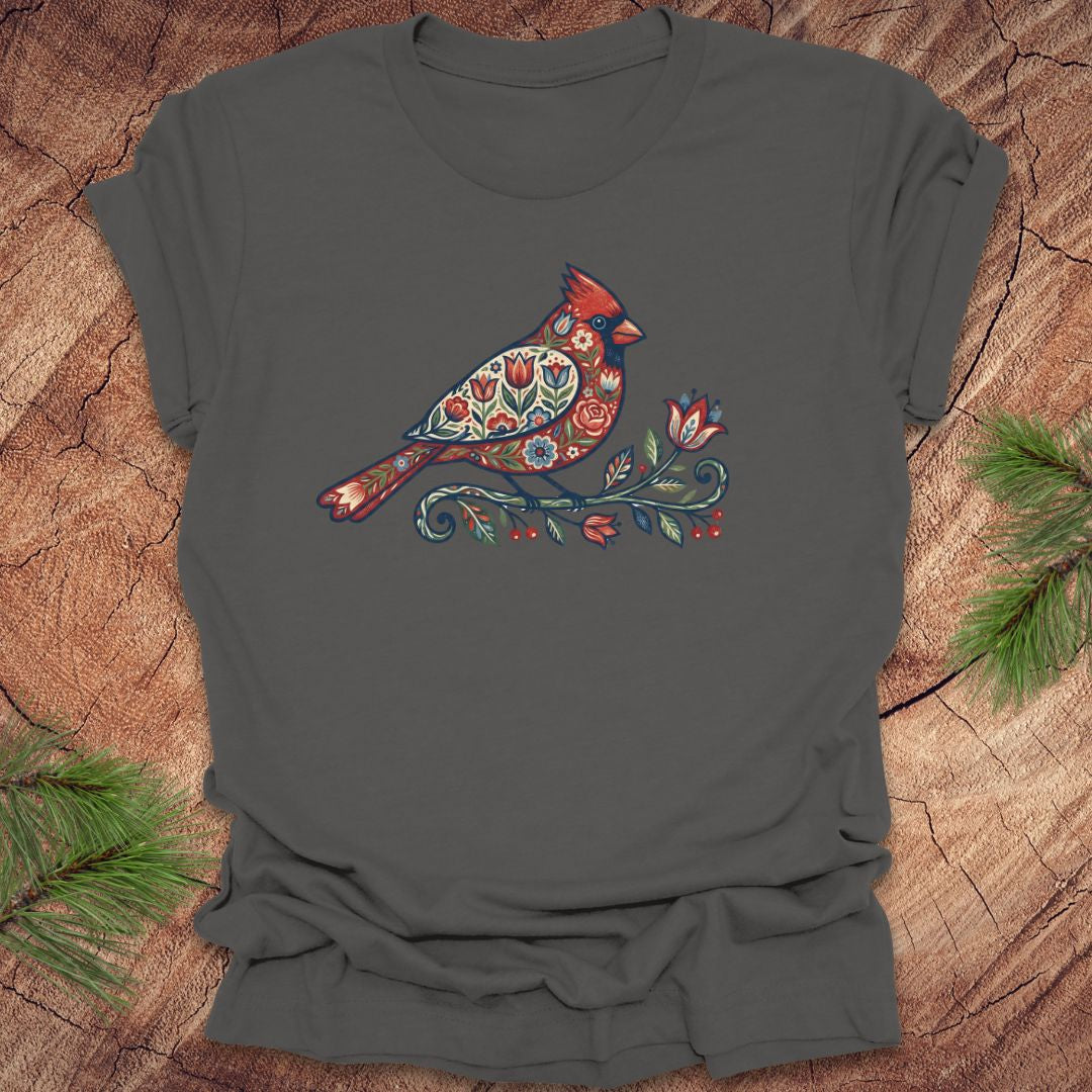 Dark grey t-shirt with a colorful cardinal and flower design on a wooden surface
