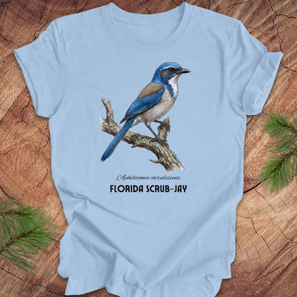 Light blue t-shirt with a Florida Scrub-Jay design on a wooden surface.