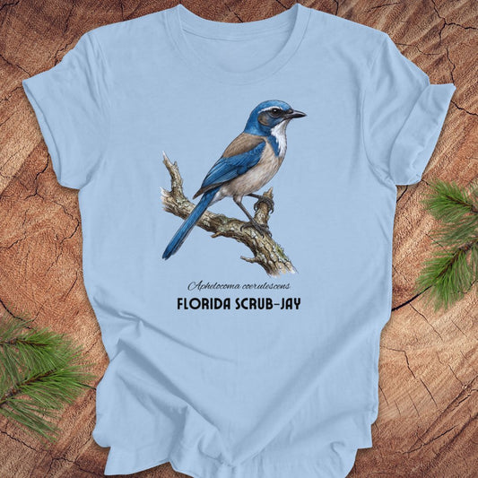 Light blue t-shirt with a Florida Scrub-Jay design on a wooden surface.