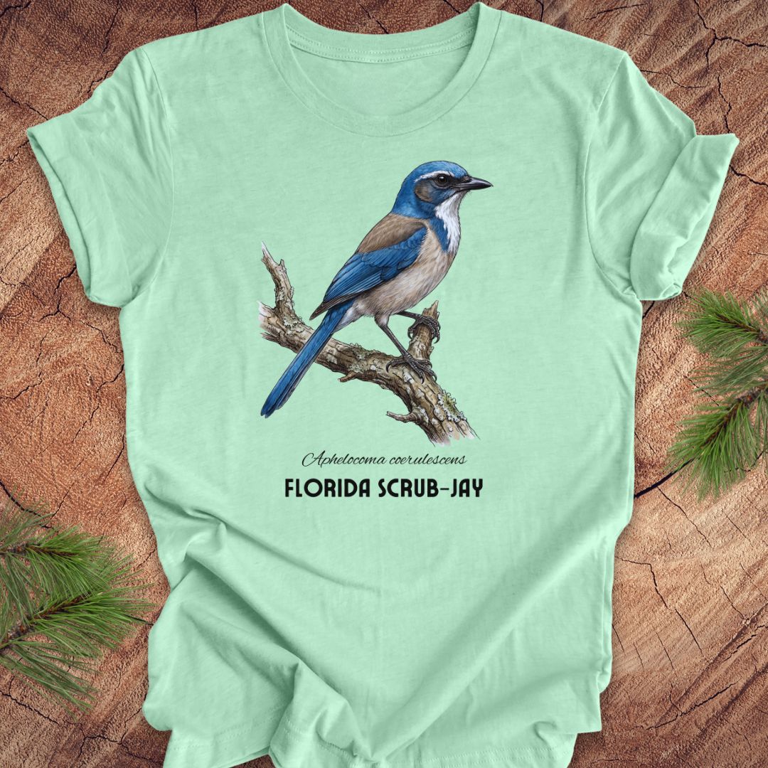Light green t-shirt with a Florida Scrub-Jay graphic on a wooden surface