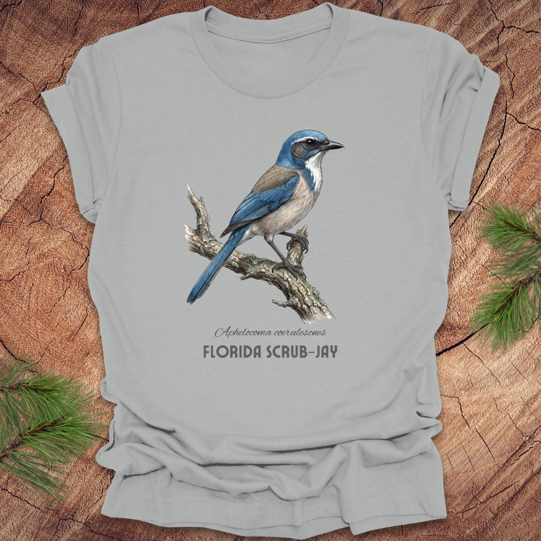 Gray t-shirt with a Florida Scrub-Jay design on a wooden surface with greenery.