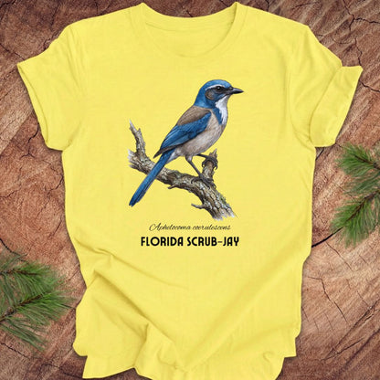 Yellow t-shirt with a Florida Scrub-Jay design on a wooden surface