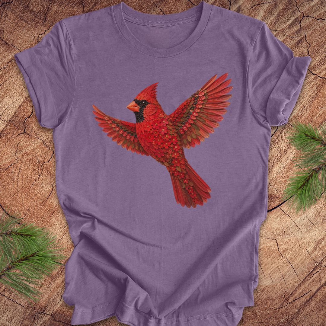 Purple t-shirt with a cardinal made of flowers on a wood background.