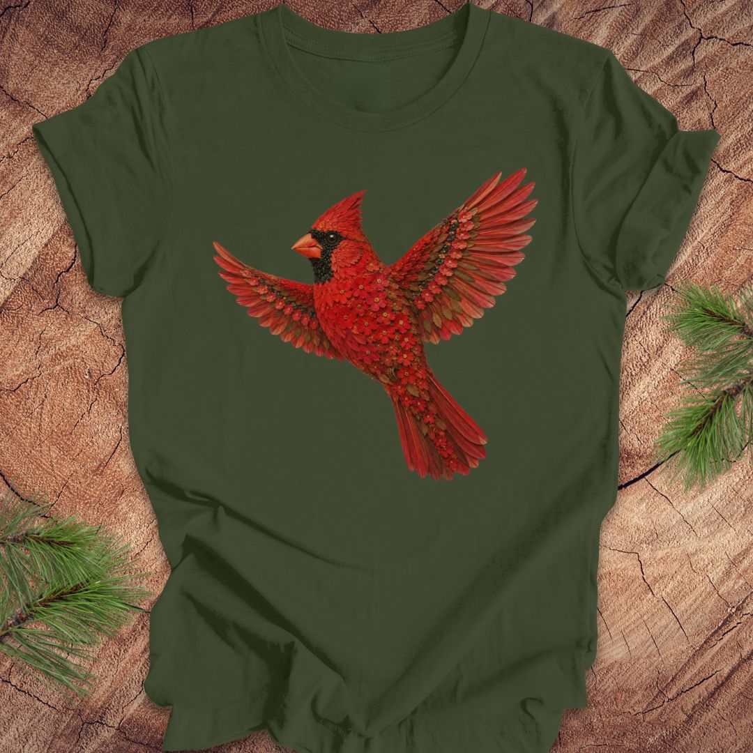 Green t-shirt with a cardinal made of flowers on a wood background.